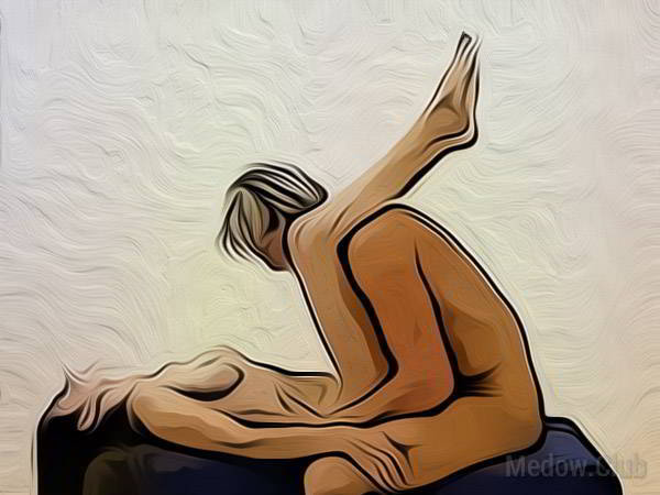 Сексуальная позиции камасутры №40 - Девушка лежит спиной на пуфике и кладет ноги на плечи сидящему позади нее парнеру. Мужчина входит в нее сзадиФото